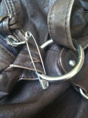 A safety pin locks a purse closed