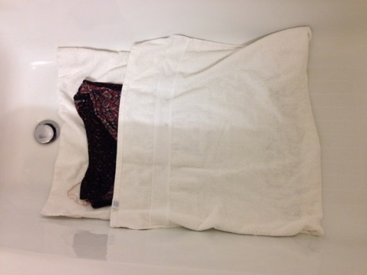 folding the towel over the garment