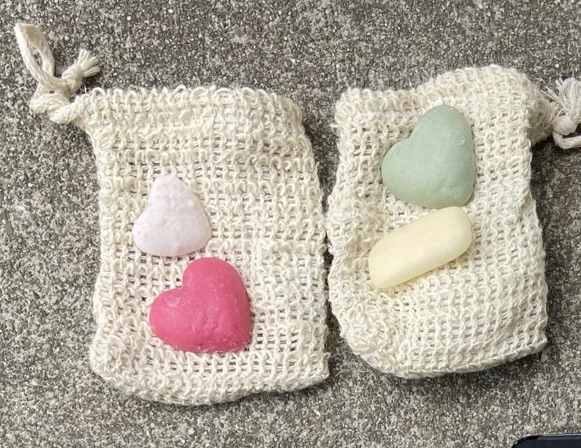 Small sample solid toiletry bars shown on top of sisal soap bags